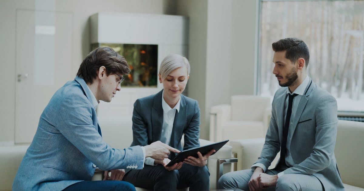Three consultants reviewing a document on a tablet